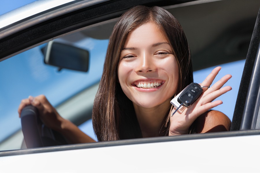 Happy asian girl teen driver showing new car keys. young woman s